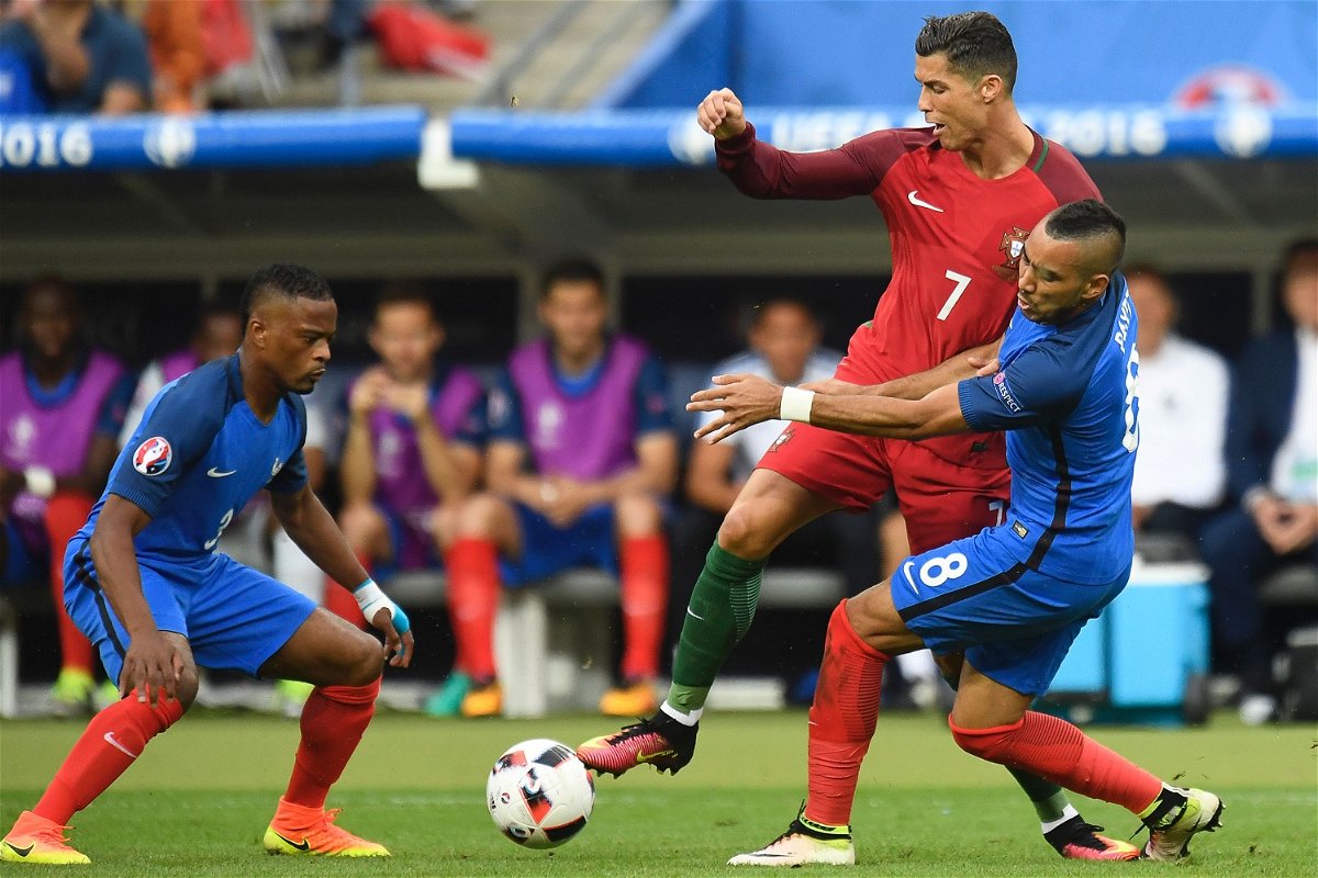 TOPSHOT - France's defender Patrice Evra (L) and France's forward Dimitri Payet vie with Portugal's forward Cristiano Ronaldo during the Euro 2016 final football match between Portugal and France at the Stade de France in Saint-Denis, north of Paris, on July 10, 2016. / AFP / PHILIPPE DESMAZES        (Photo credit should read PHILIPPE DESMAZES/AFP/Getty Images)